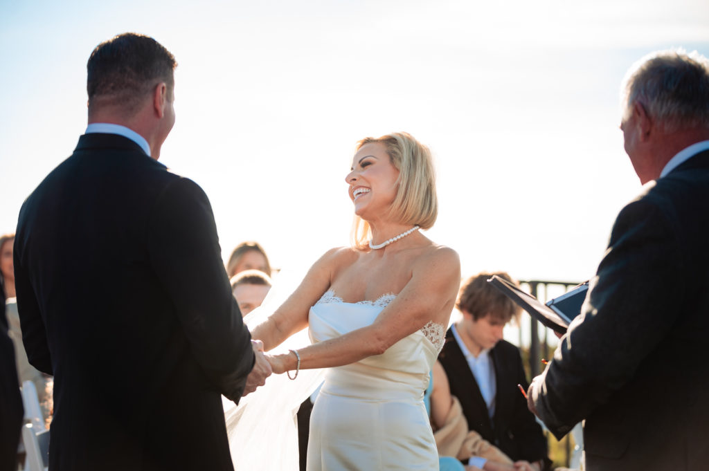 couple smiling at each other during their beach wedding ceremony held outside the Ritz-Carlton Half Moon Bay