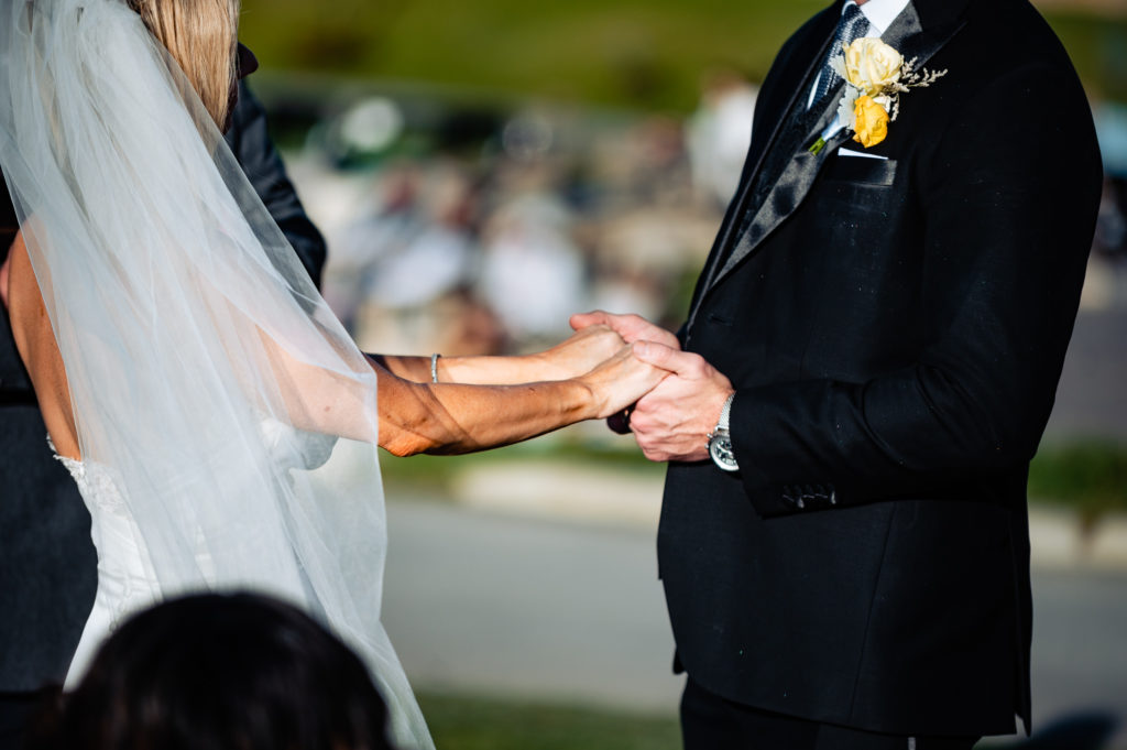 couple holding hands during their beach wedding ceremony held outside the Ritz-Carlton Half Moon Bay