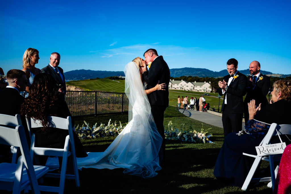 couple's first kiss after the beach wedding ceremony held outside the Ritz-Carlton Half Moon Bay