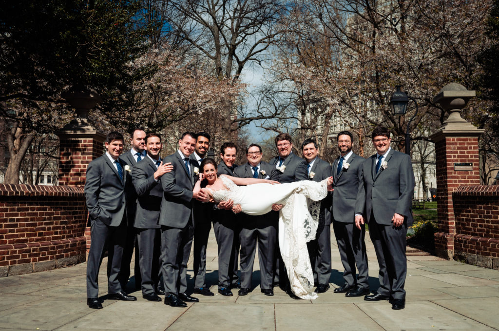 bride being carried by the groom and groomsmen