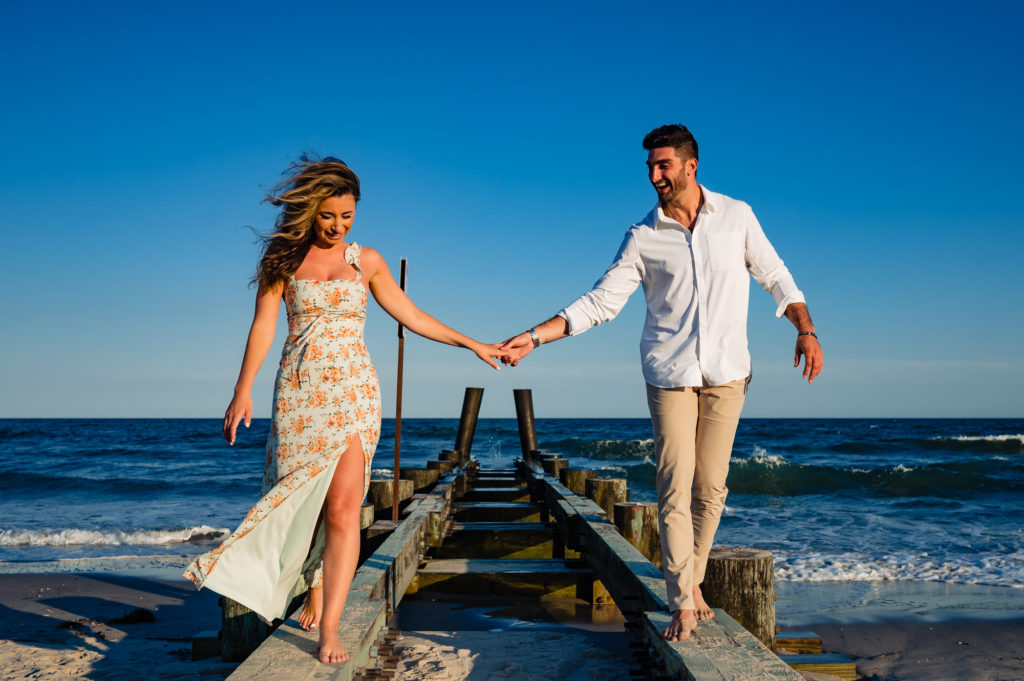 couple on top of the bridge holding each other's hand during their margate new jersey e-shoot