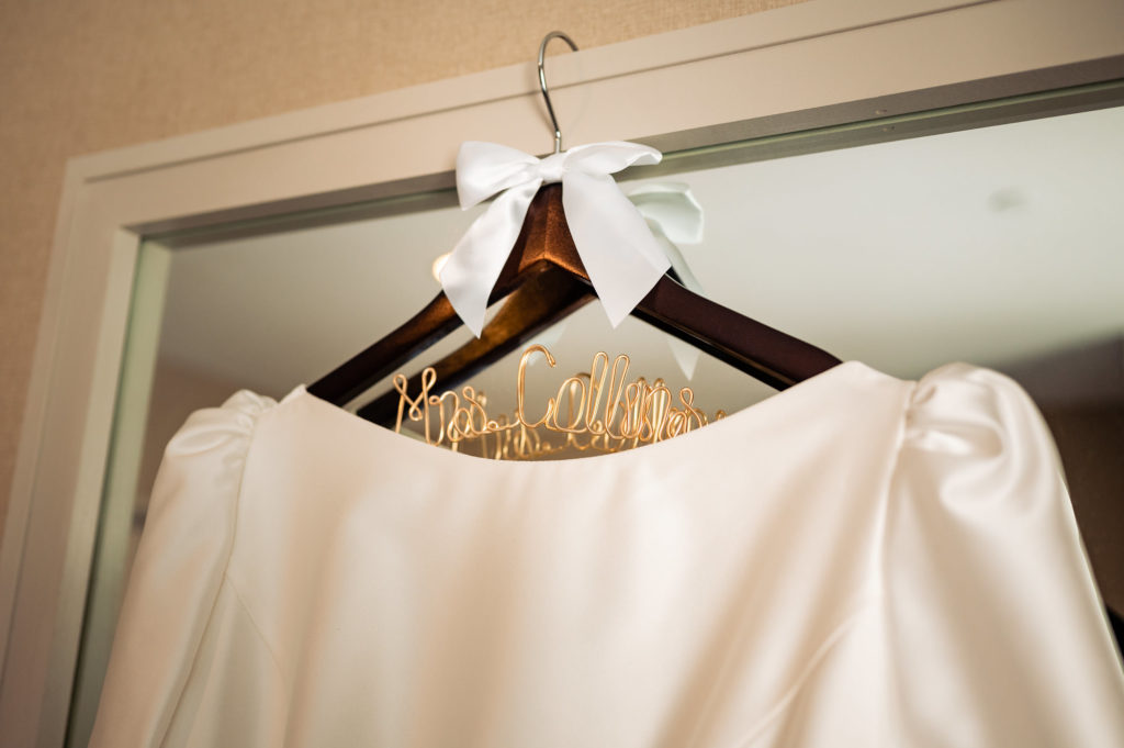the bride's wedding dress on the hanger