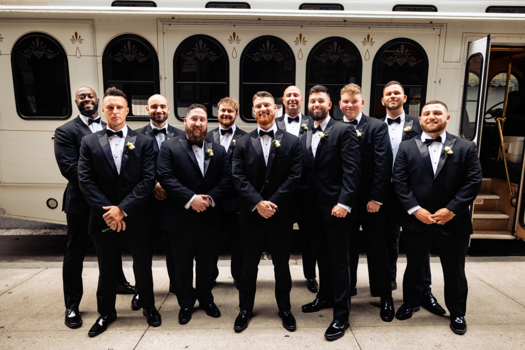groom and groomsmen poses for the camera