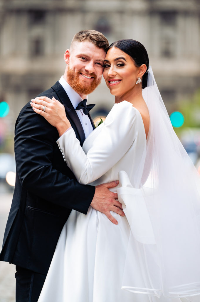 portrait shot of the groom and bride smiling at the camera