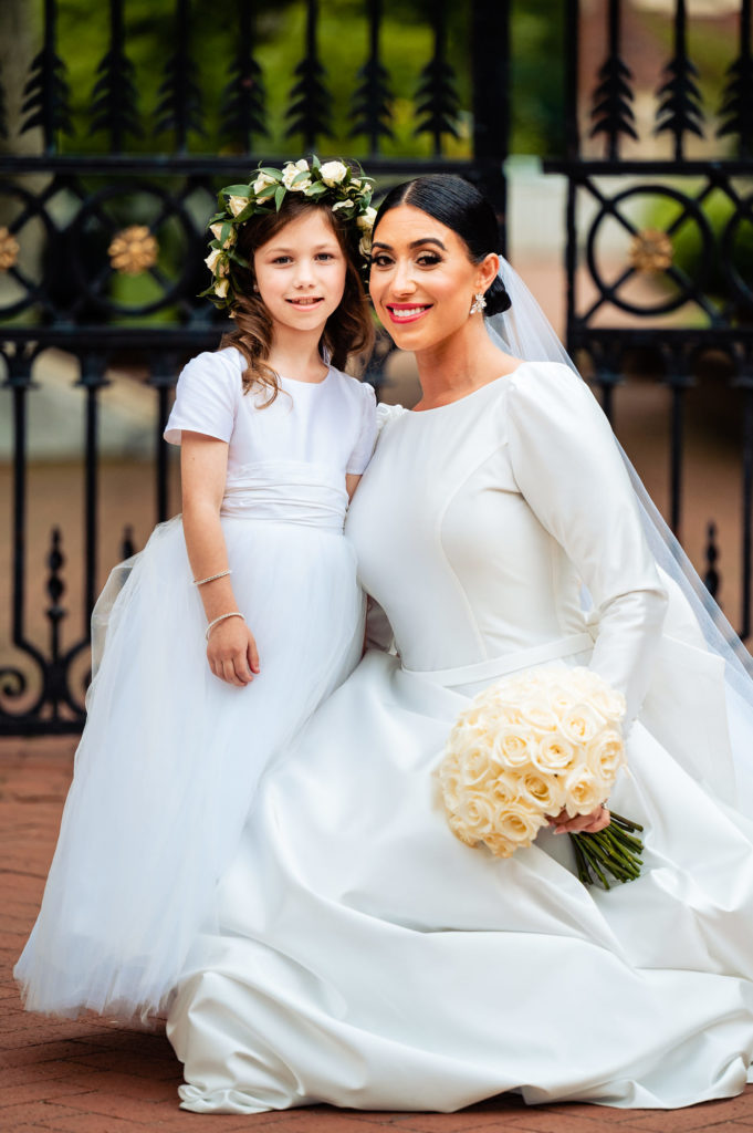 bride poses with one of the flower girls
