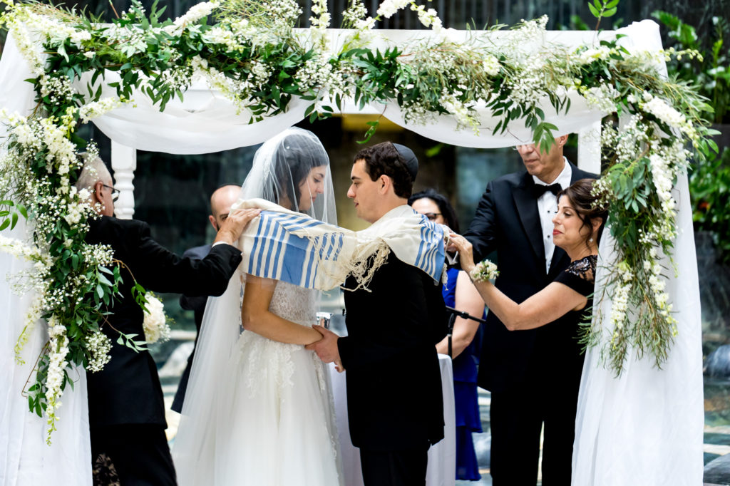 bride and groom under the chuppah during their curtis atrium wedding