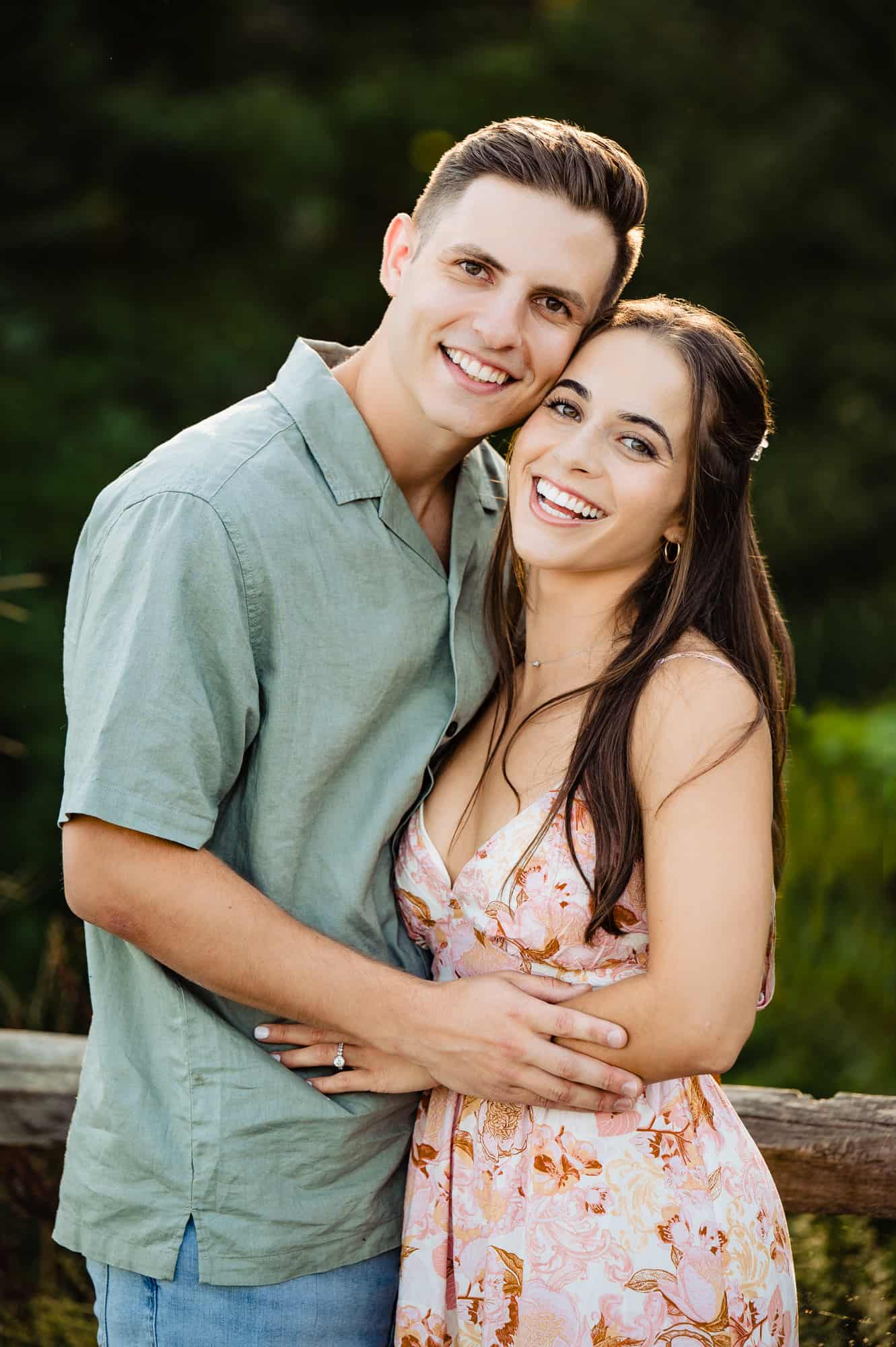 Indian couple posing for maternity baby shoot. The couple is posing in a  lawn with green