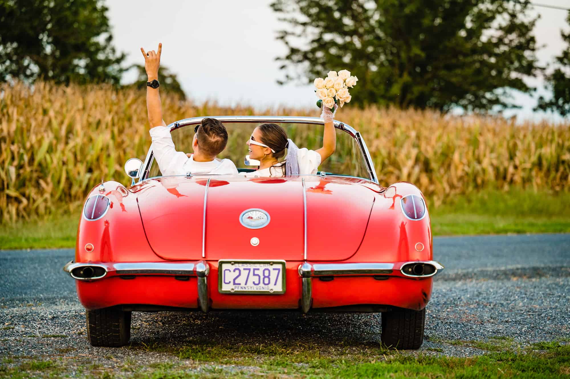 couple pose in their vintage corvette during their engagement session at autumn lake winery