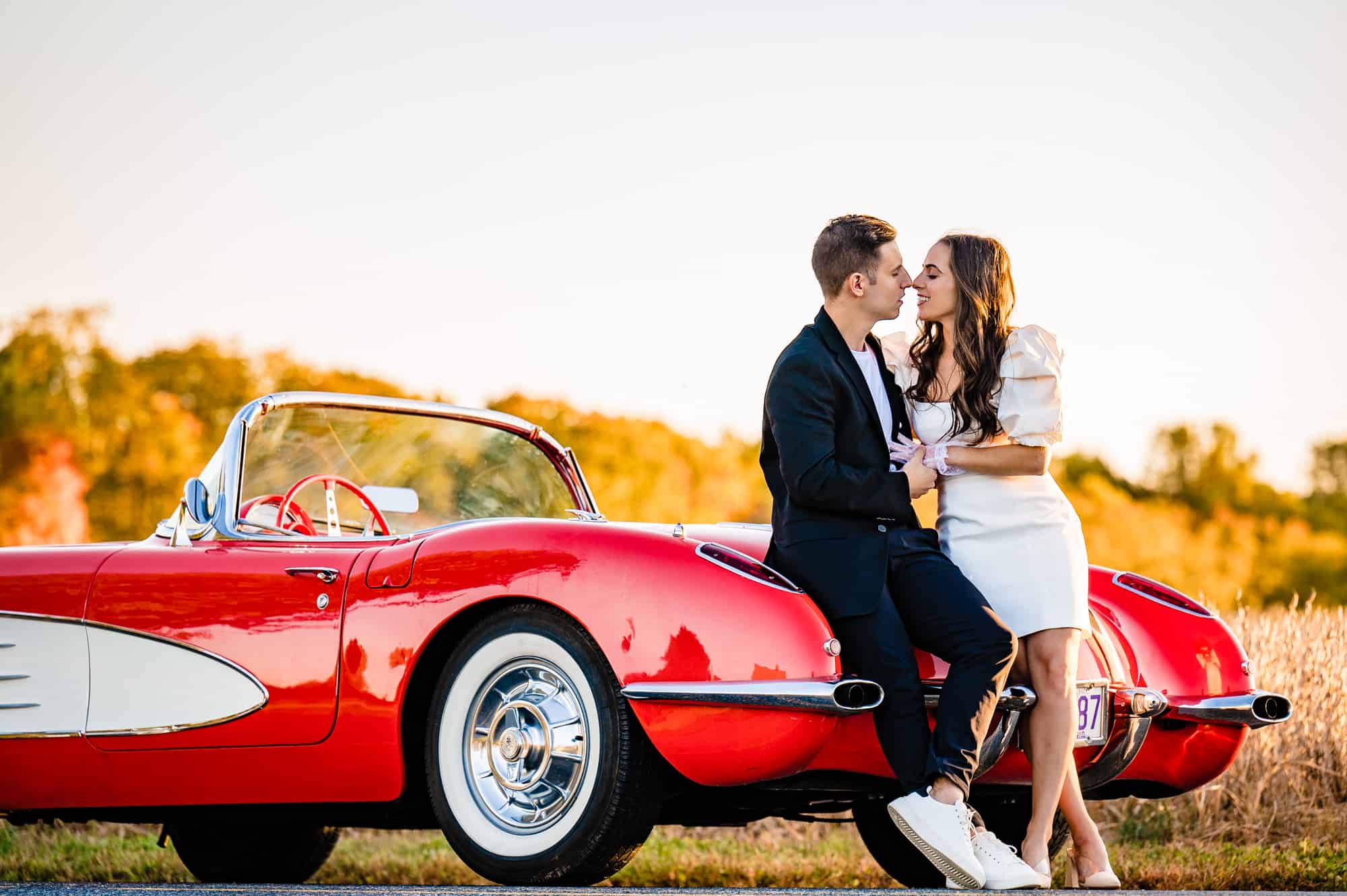 couple having intimate moment at the back of their vintage corvette