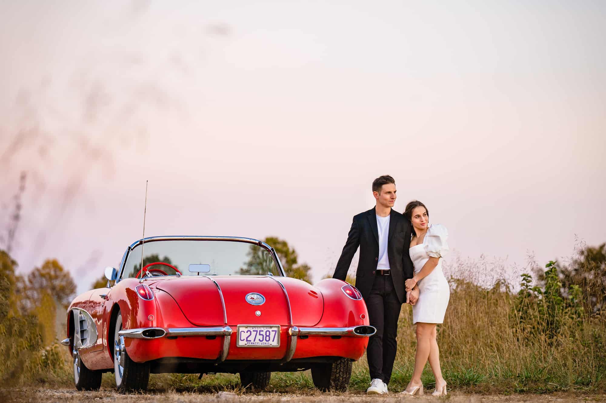 couple taking a pose with their vintage corvette during their vintage new jersey engagement shoot