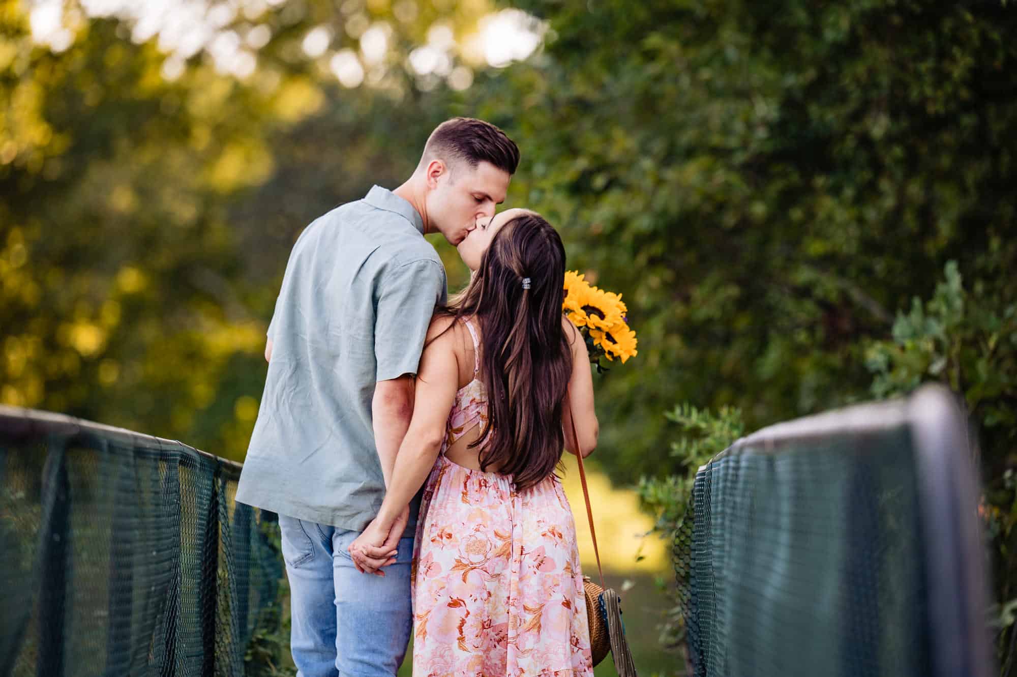 couple kisses on top of a bridge in the park during their new jersey engagement photoshoot