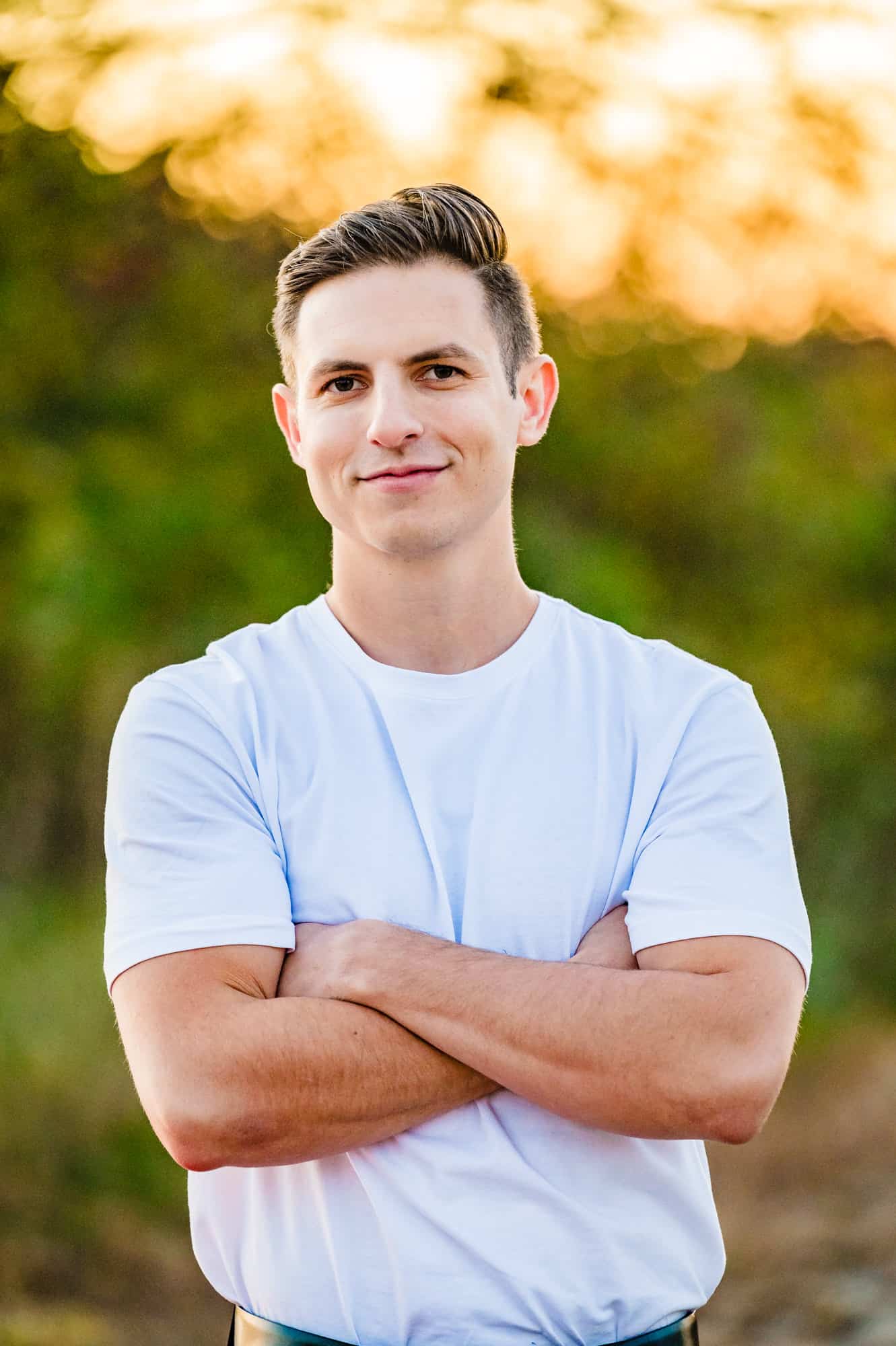 a handsome groom wearing a white shirt smiling before the camera