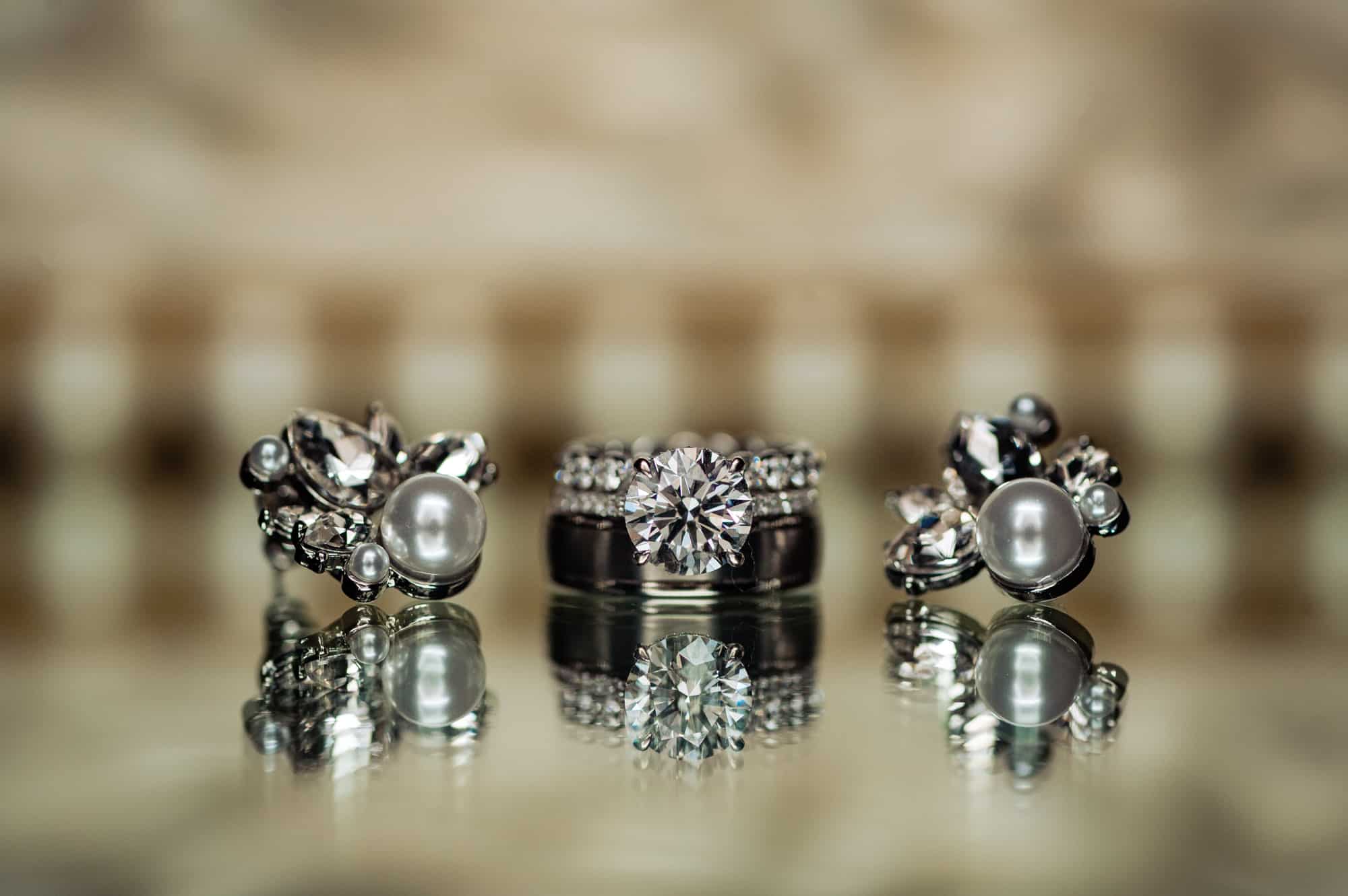 a pair of pearl earrings with the engagement ring and a wedding band