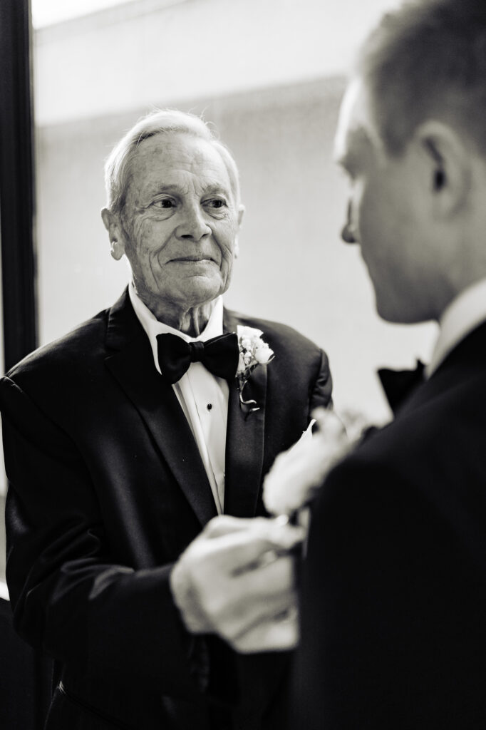 groom's dad fixing his suit black and white shot
