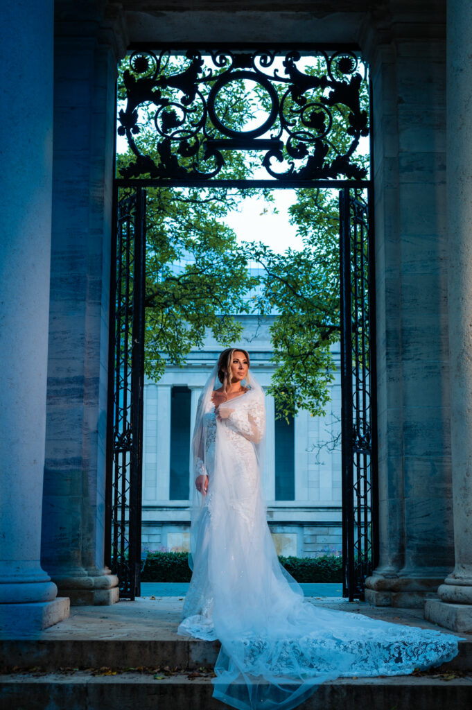 bride posing in front of a gate