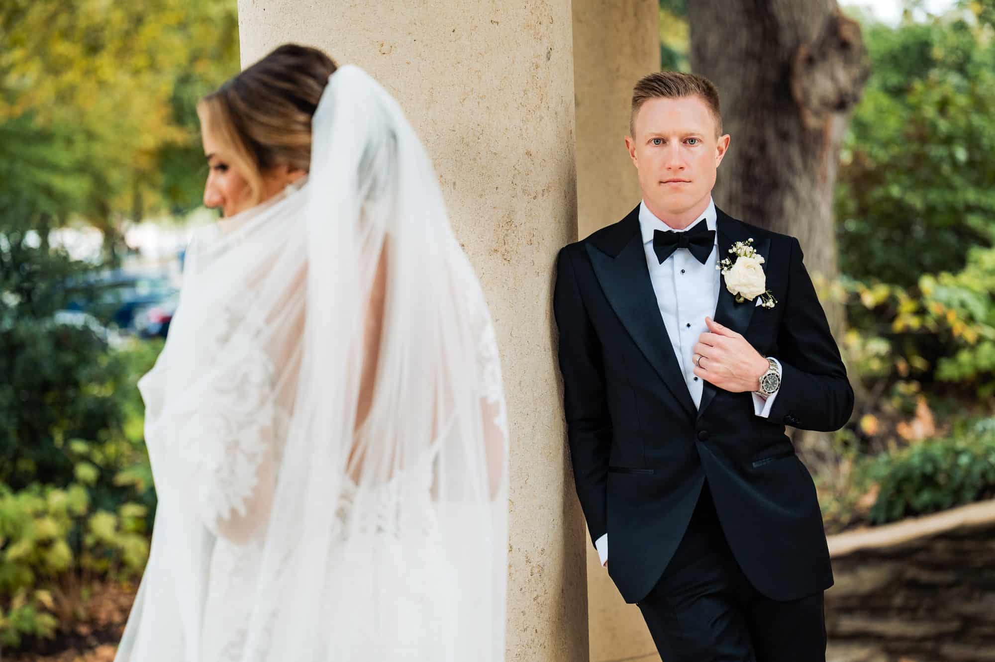 groom facing the camera and bride facing away