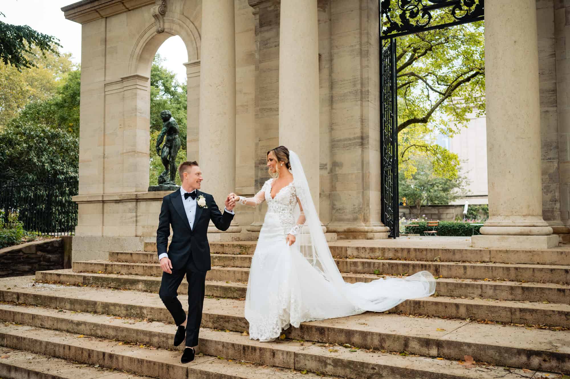 couple holding each other's hands and smiling going down the stairs