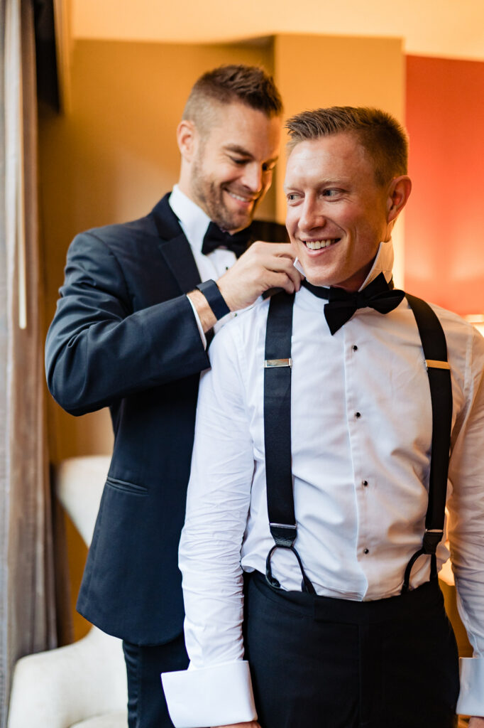man of honor fixing the groom's suit