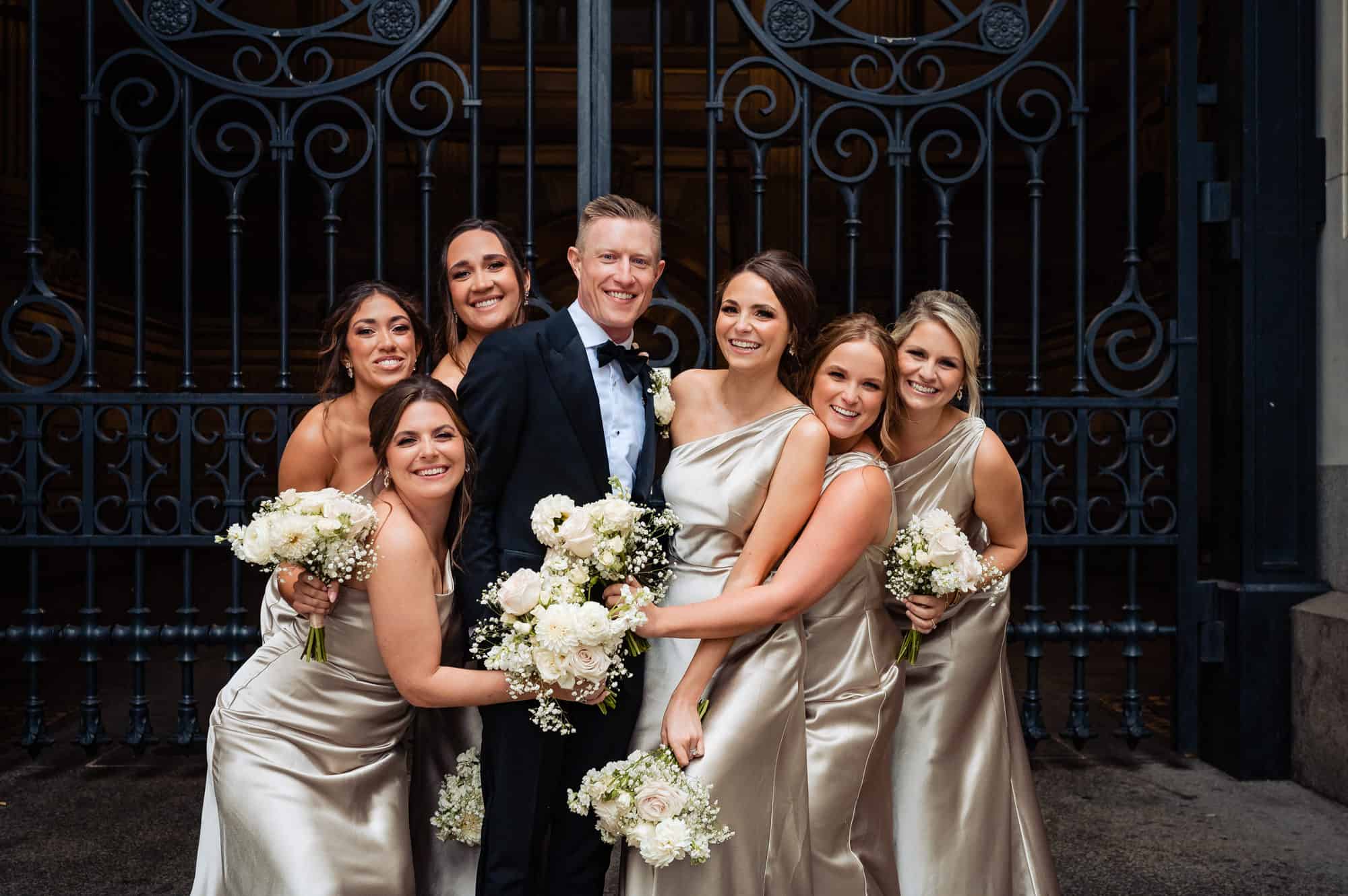 groom posing with the bridesmaids