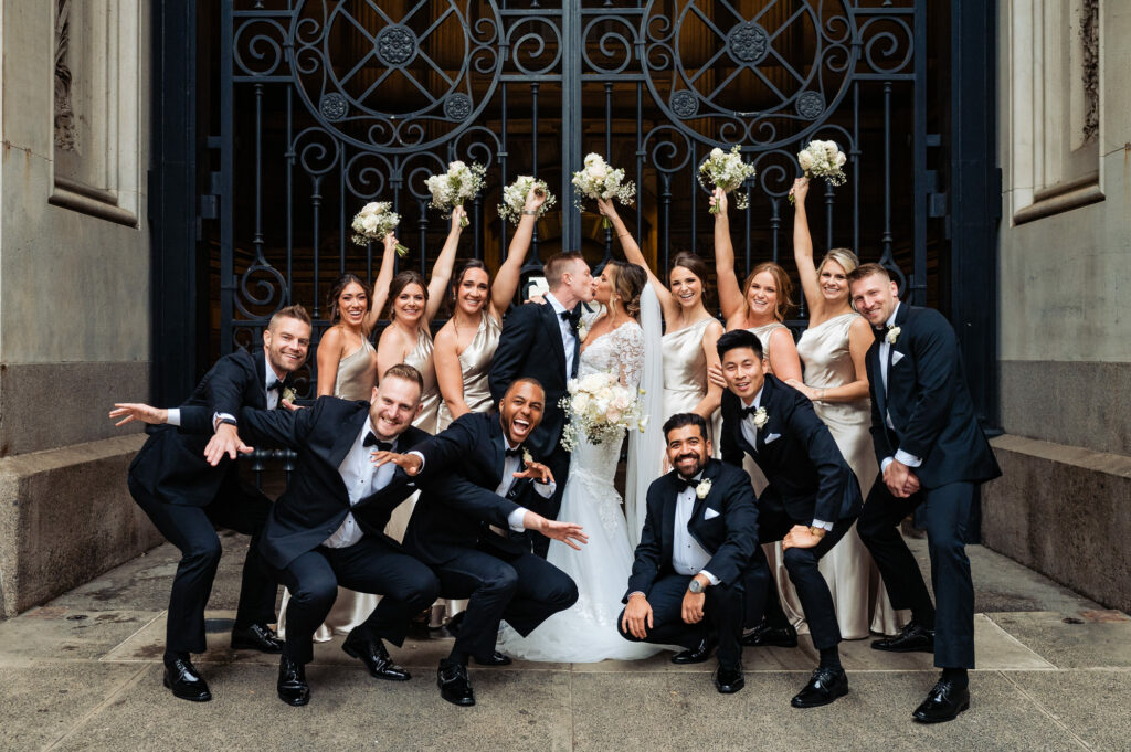 couple kissing with the groomsmen and bridesmaids