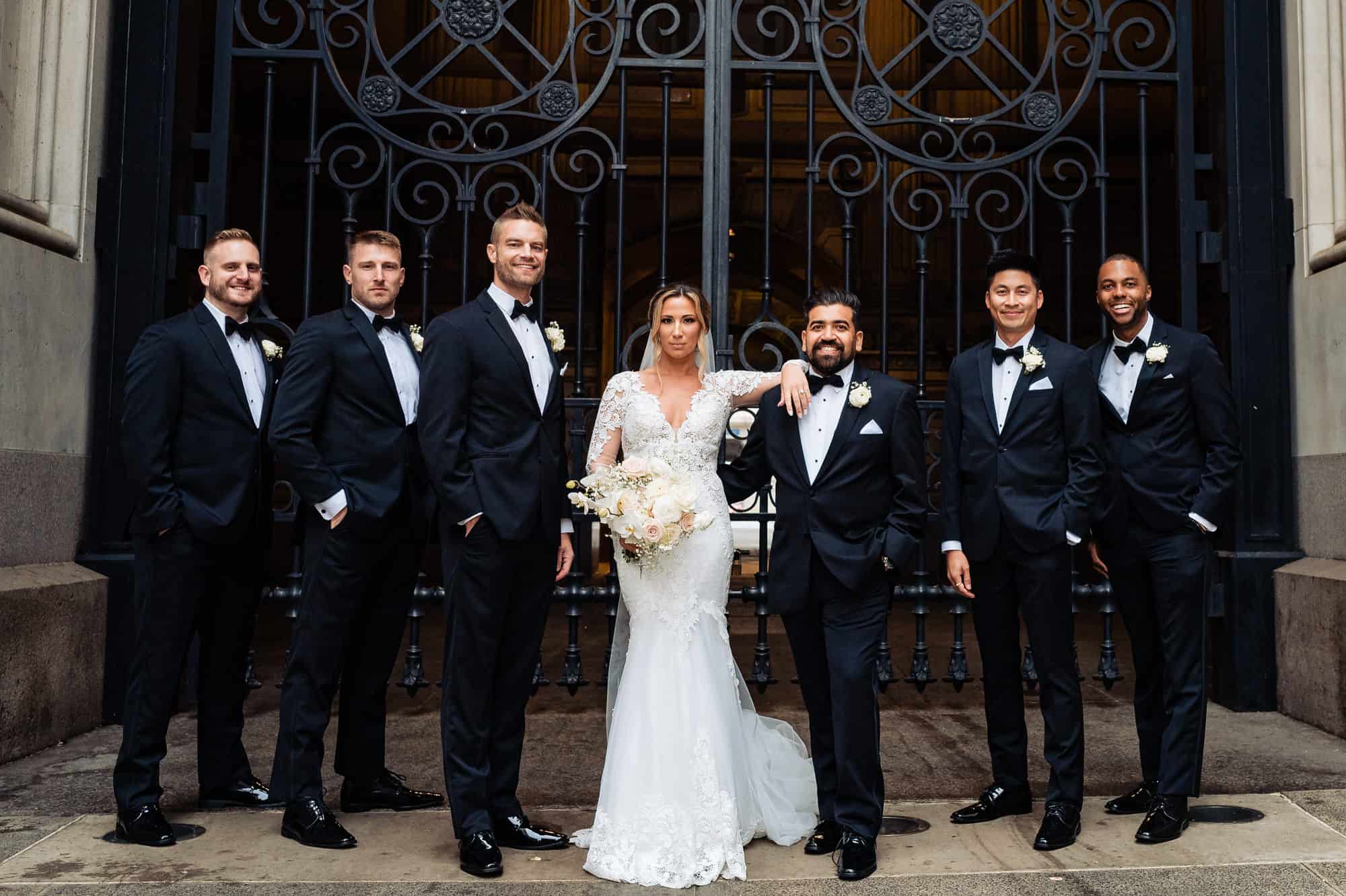 bride posing with the groomsmen