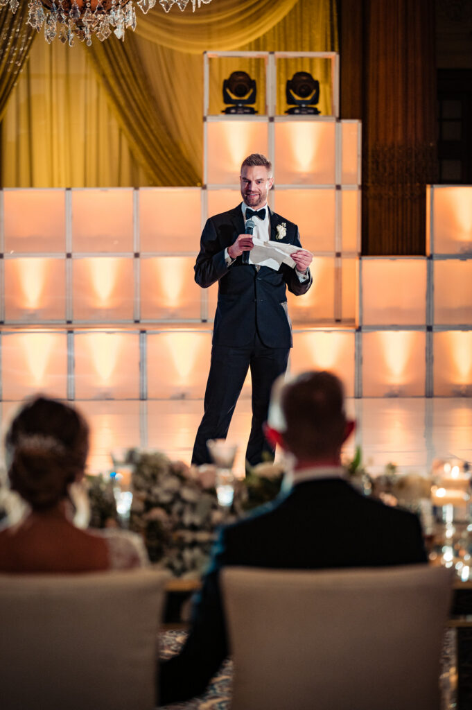 groomsman reading a letter for the newlyweds