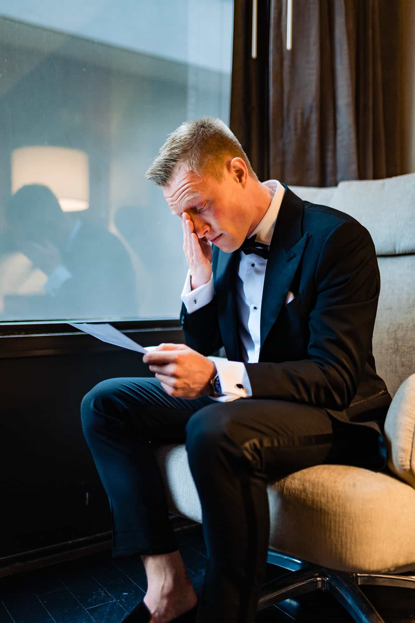 groom tearing up while reading the bride's wedding letter