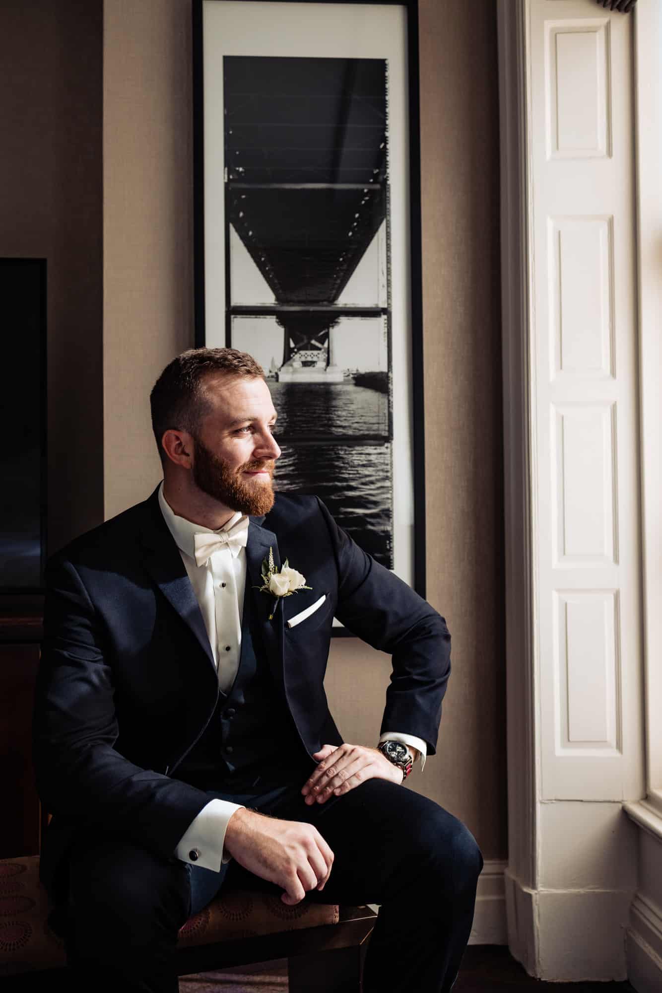 Groom sitting while looking in the window