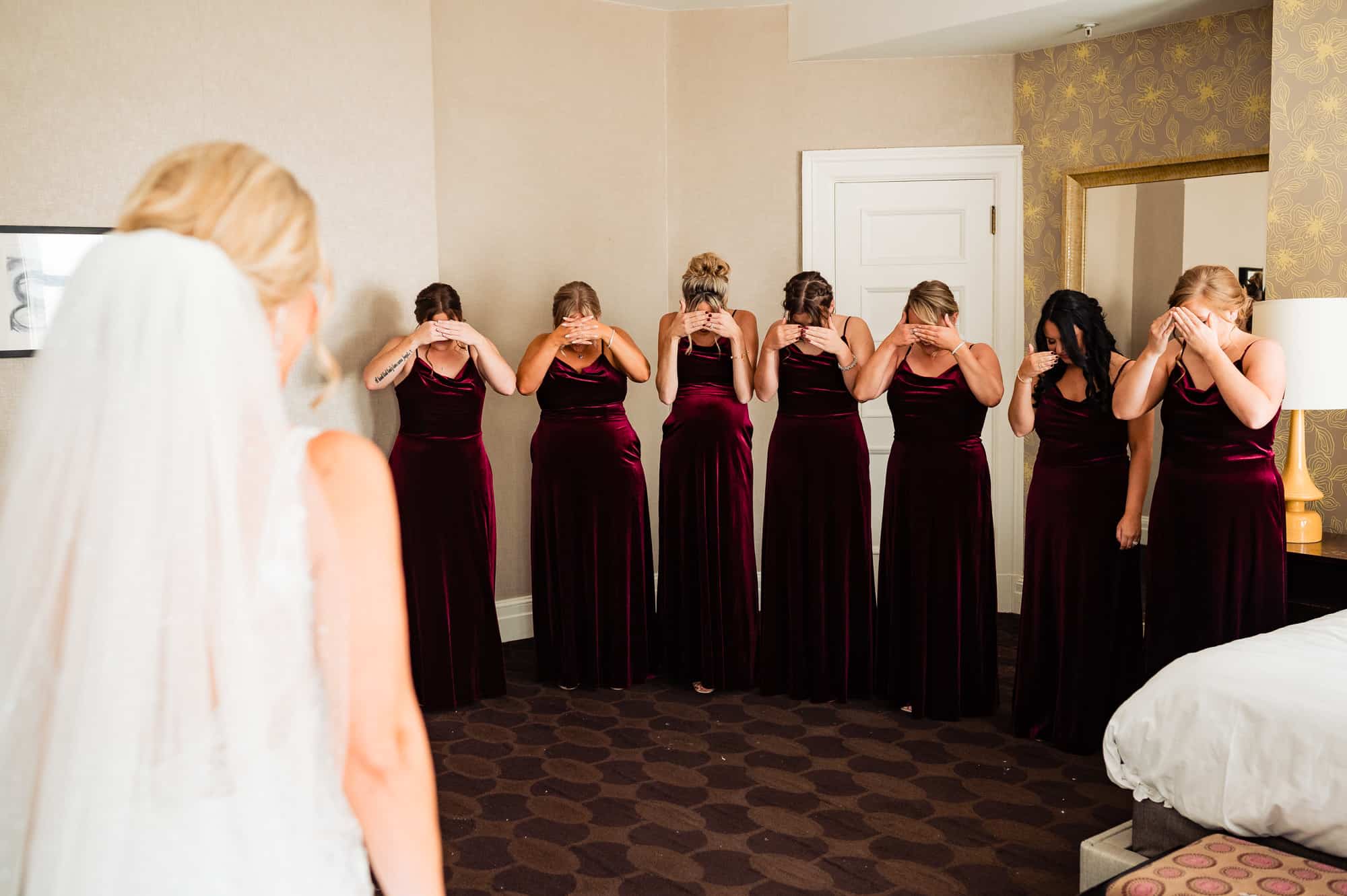 bridesmaids covering their eyes for their bride's first look