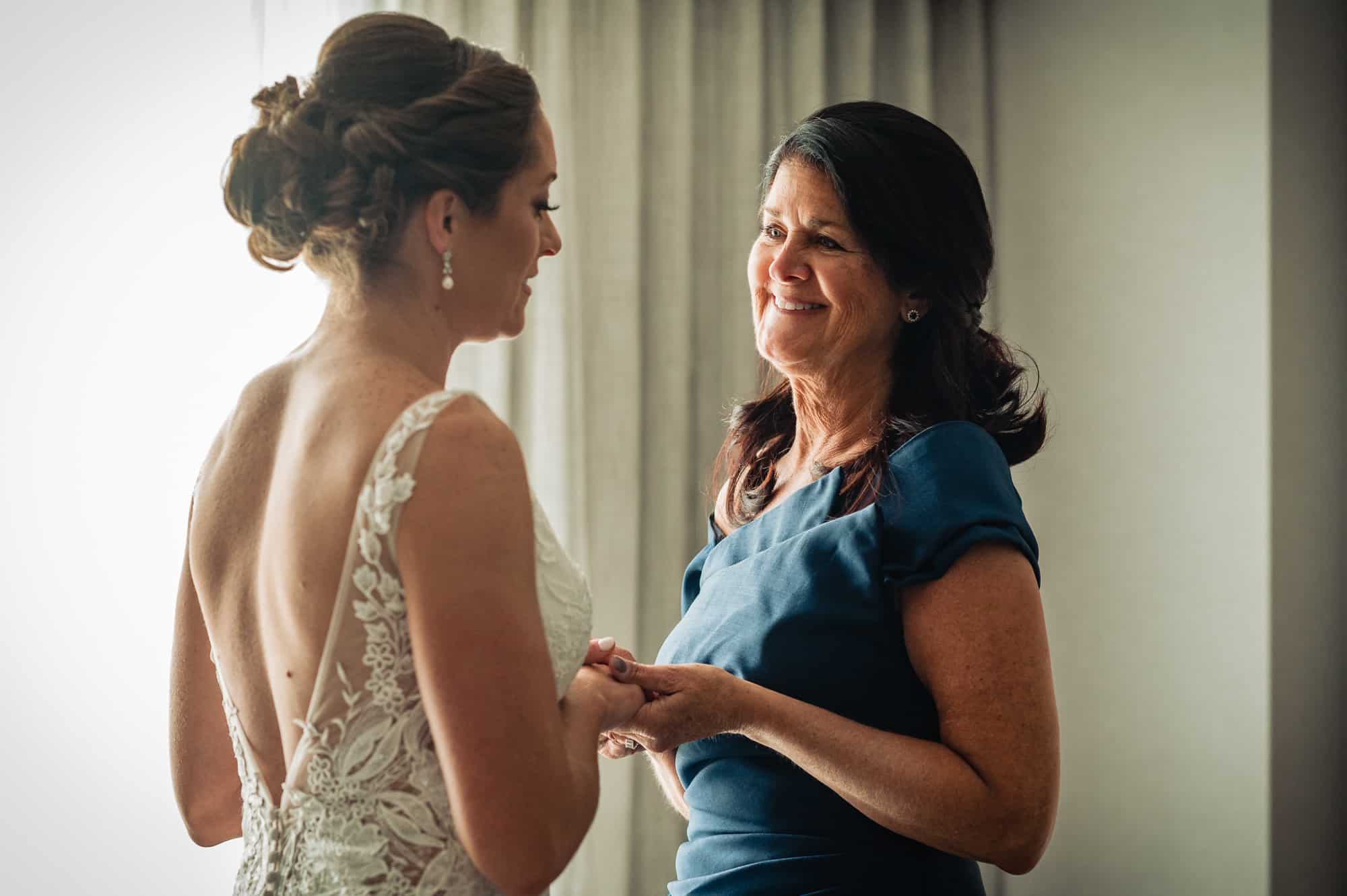 bride and her mother holding hands