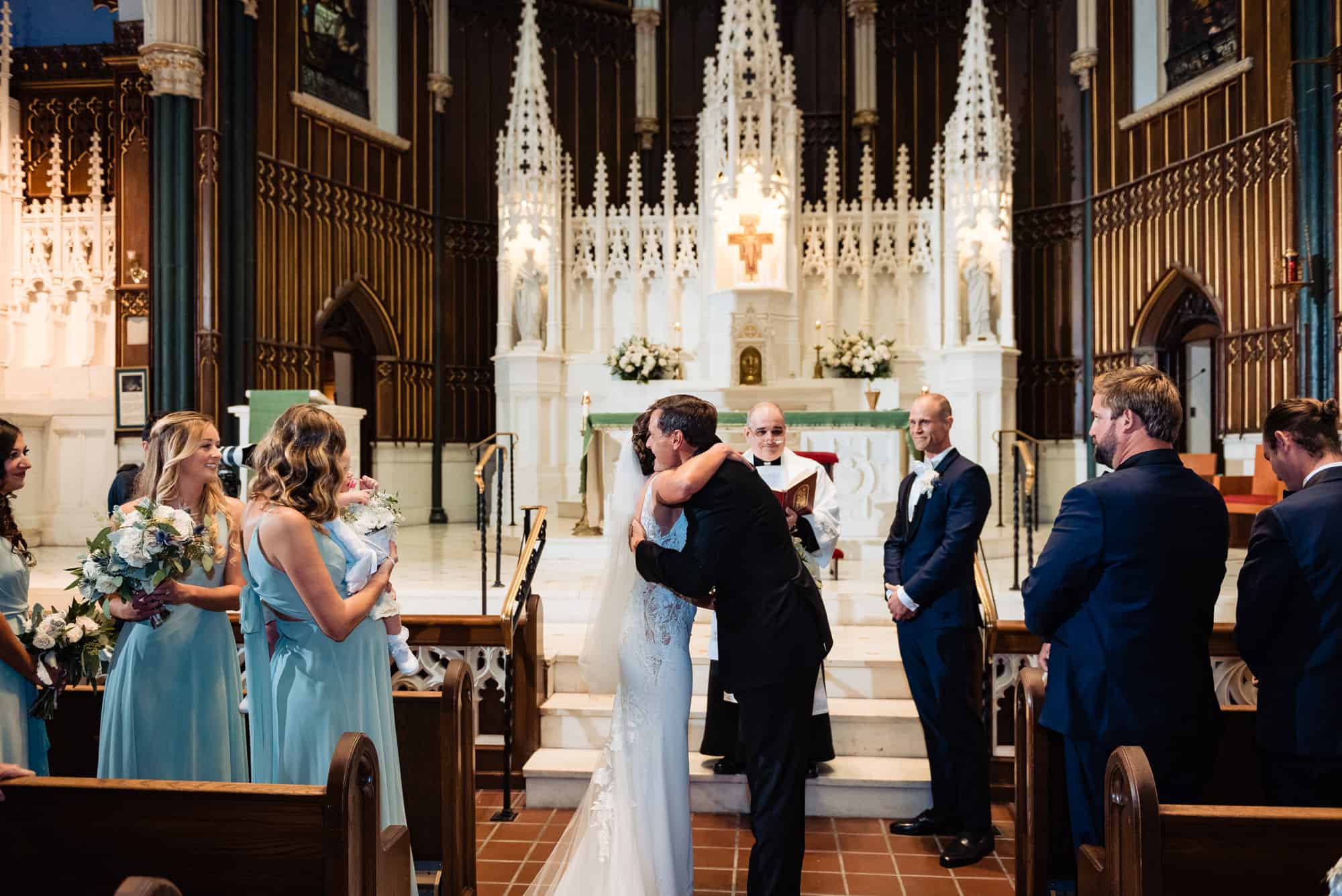 bride and her father hugging on the altar