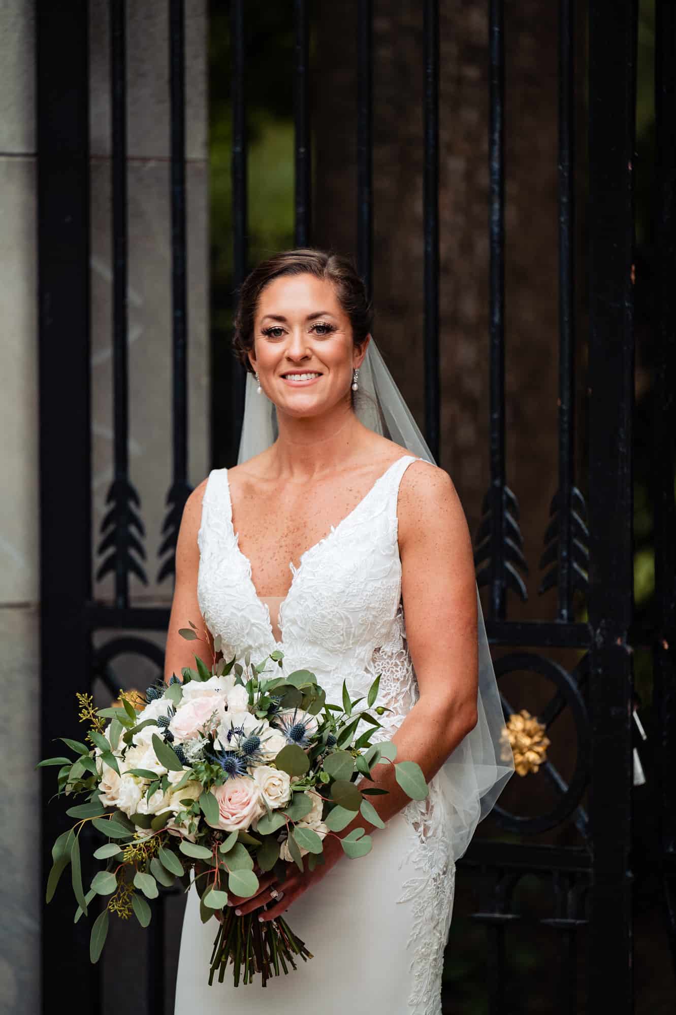 bride smile for the camera holding her bridal bouquet