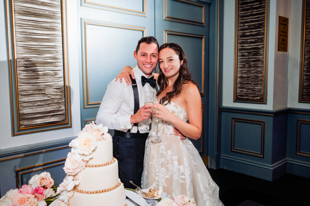 the newlyweds pose after eating their wedding cake