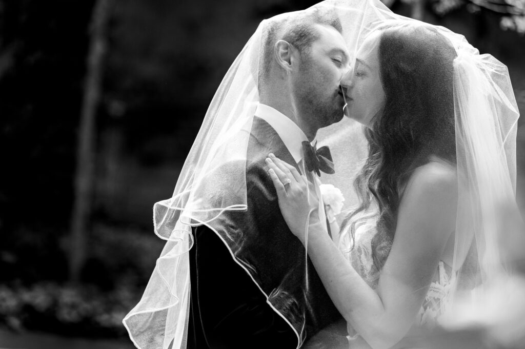 black and white shot of the newlywed's first kiss after their wedding ceremony