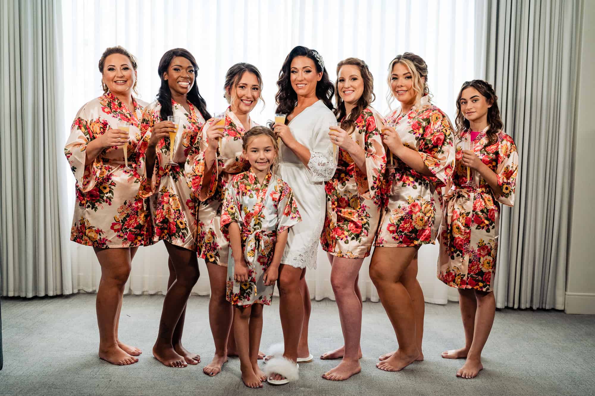 bride and her bridesmaid's in their sleeping robes holding their glass of champagnes