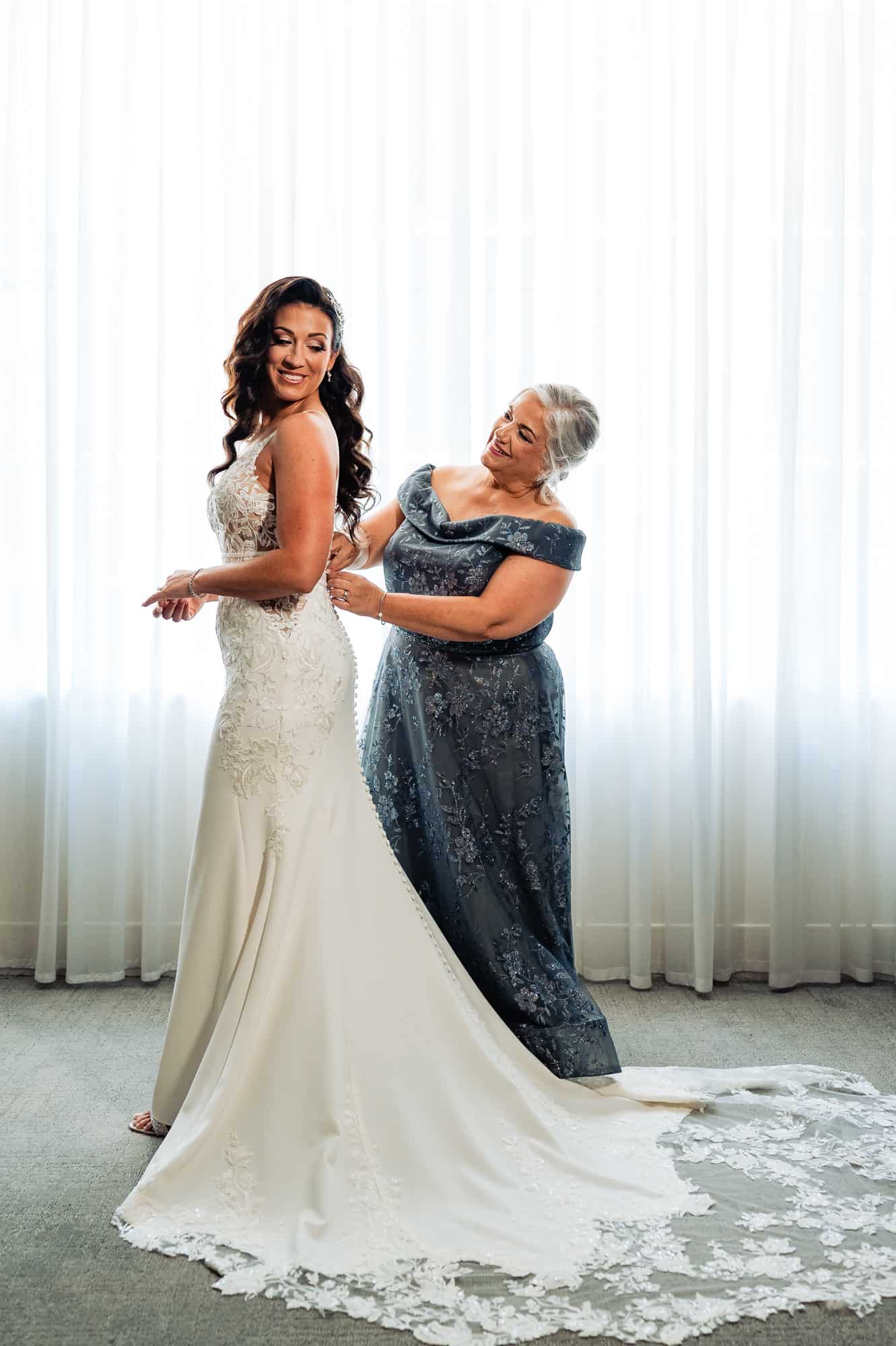 bride getting ready with the help of her mother