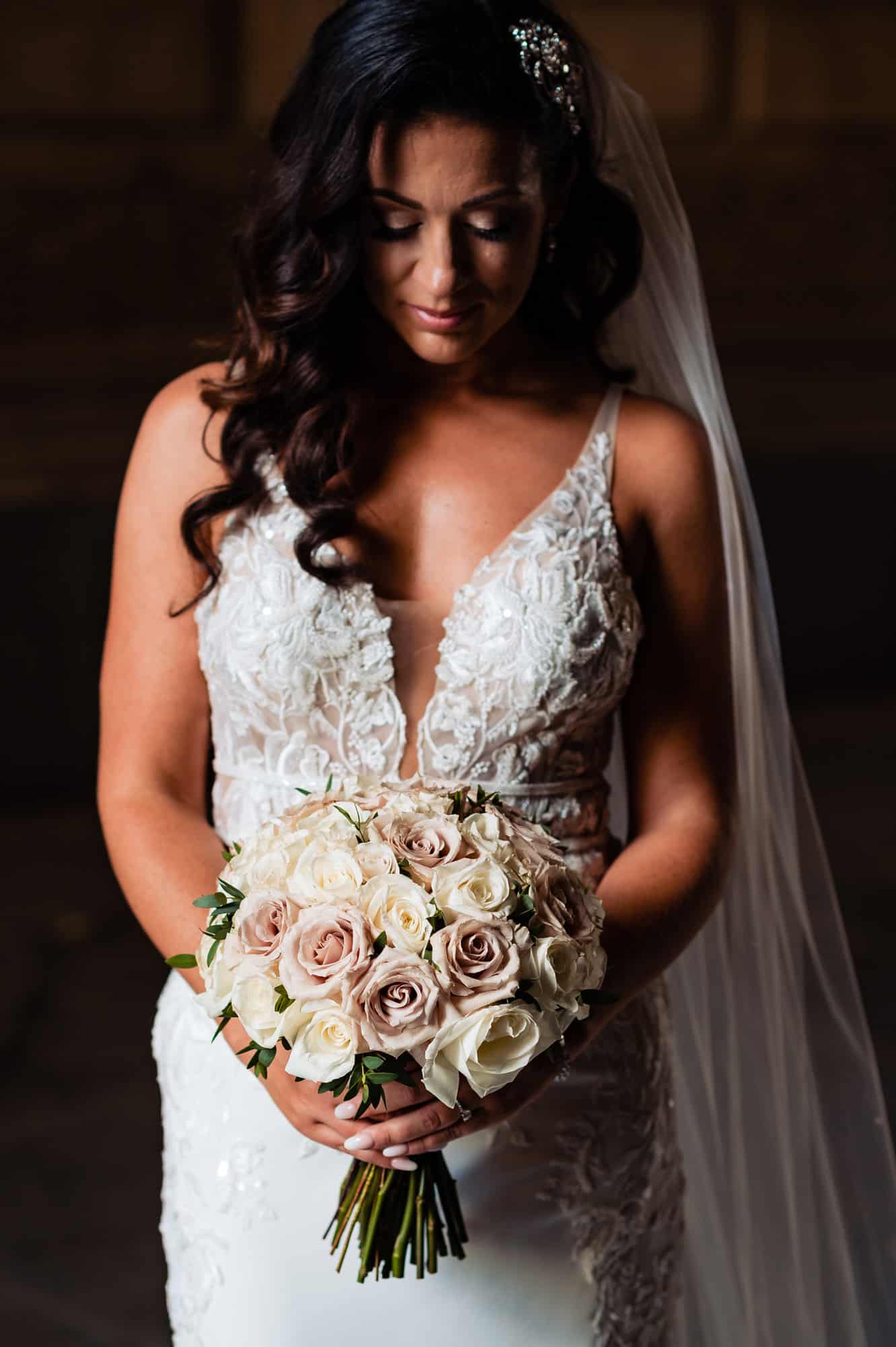 bride looks down while holding her bouquet