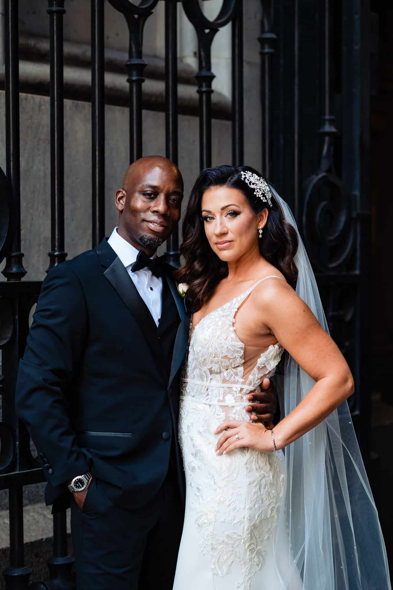 couple takes a pose behind a black ironed gate