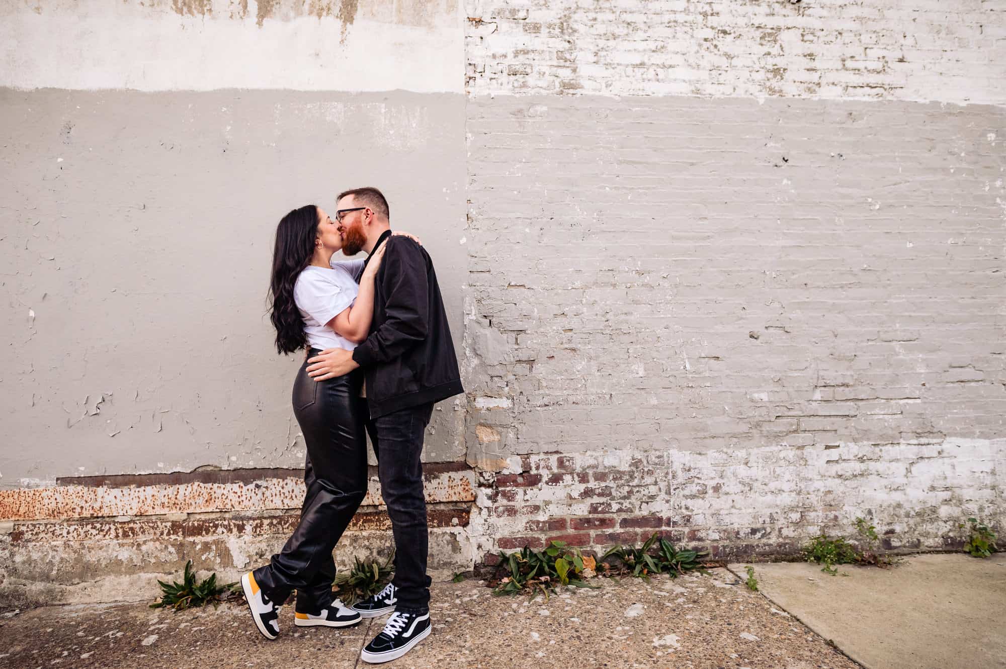 couple sharing a sweet kiss in an alley during their fun south philly engagement shoot