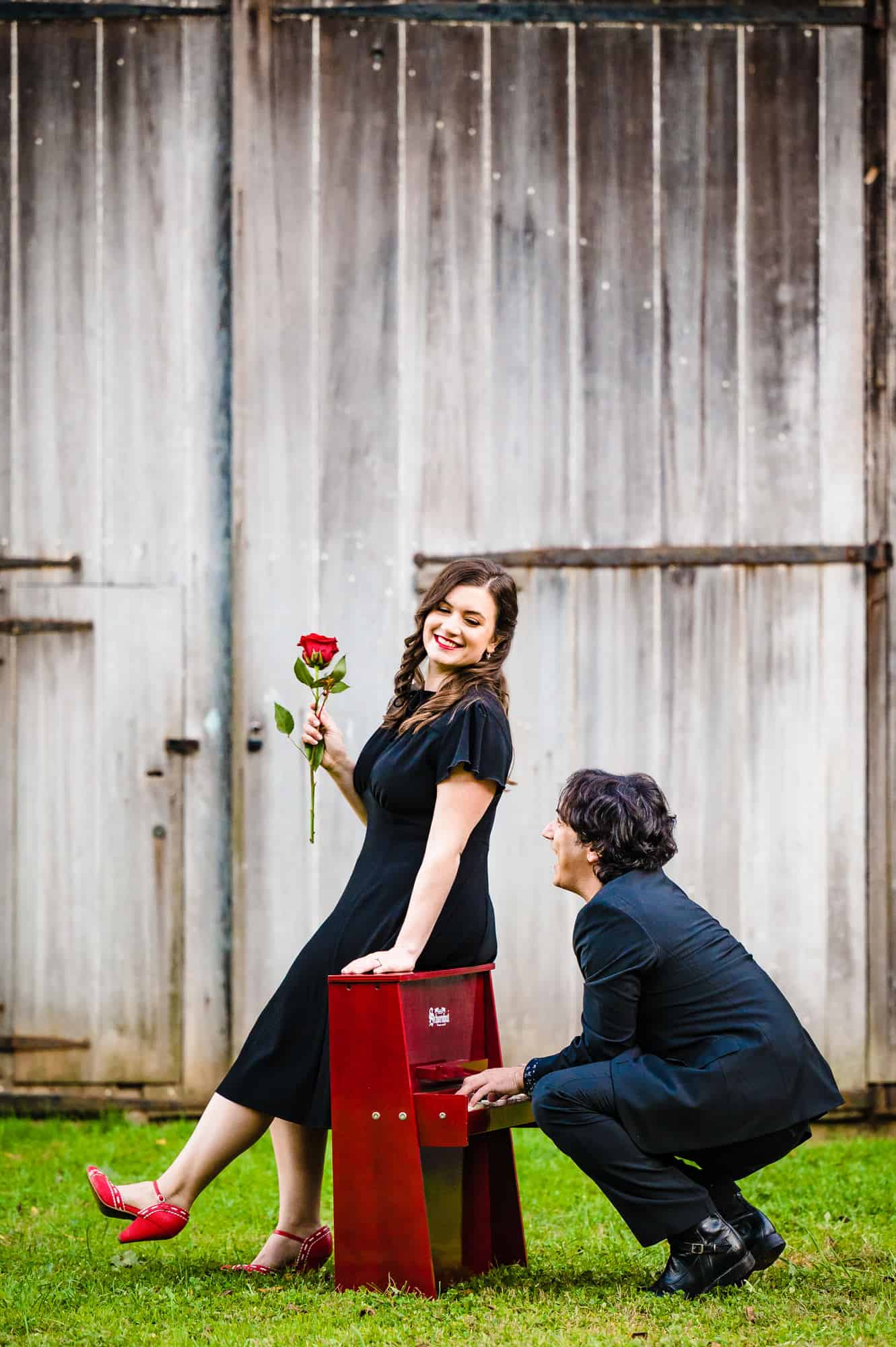 couple taking a pose outside a barn during their classic engagement photoshoot