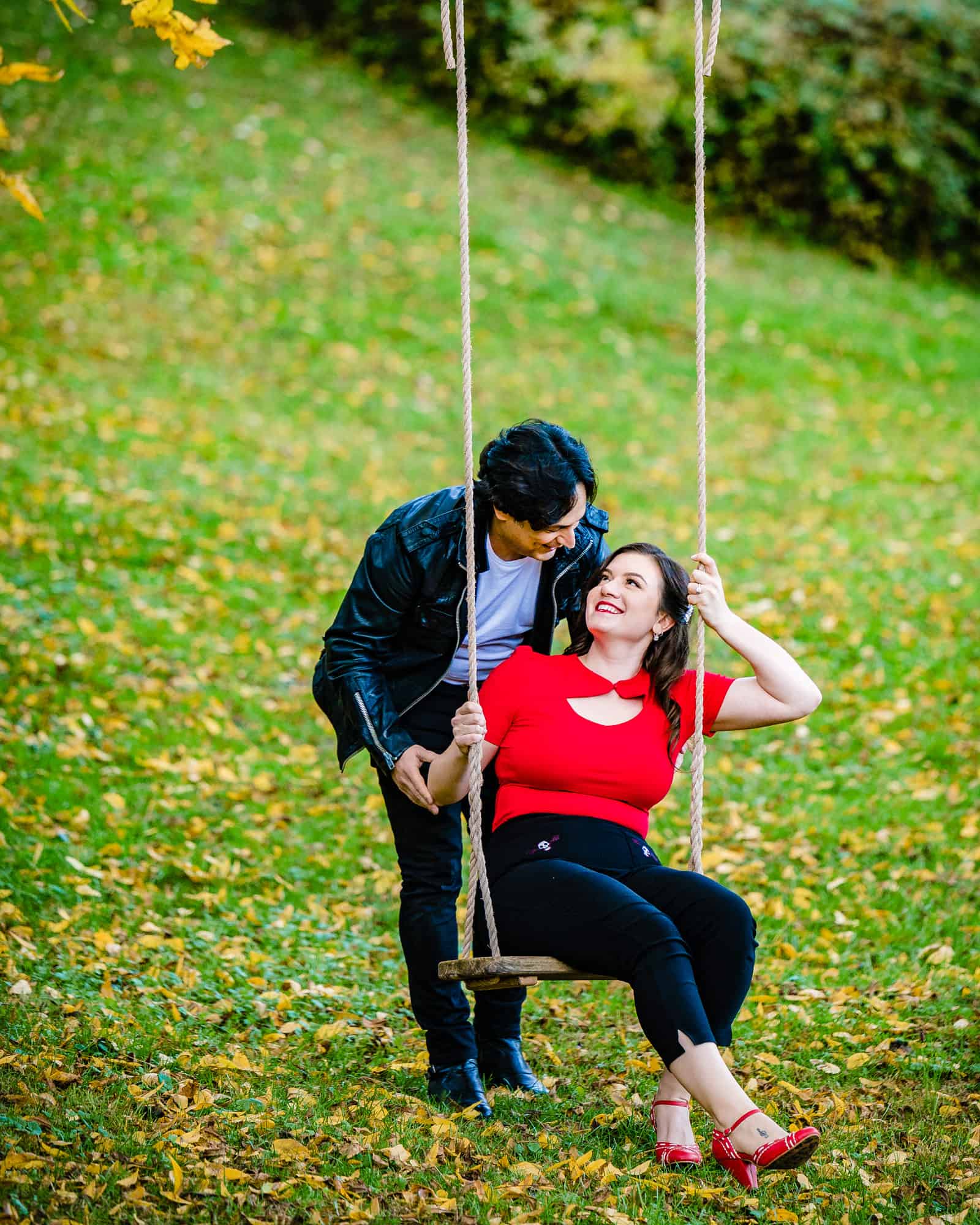 couple having a tender moment on a swing during their classic engagement photoshoot captured by ralph deal photography