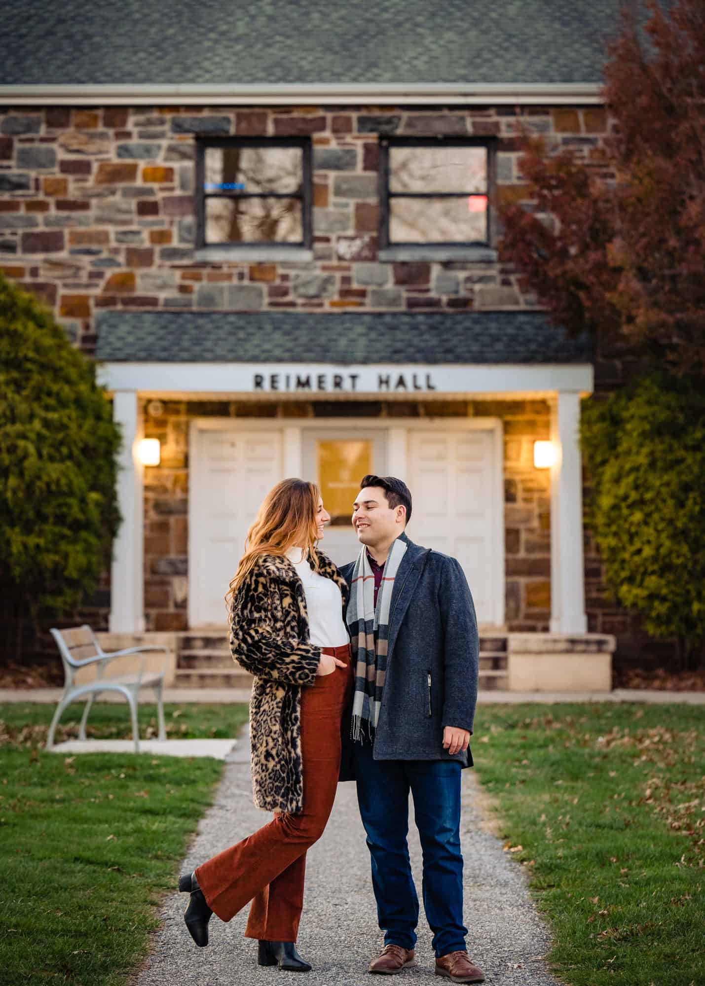 couple taking a candid pose in front of the reimert hall in philadelphia