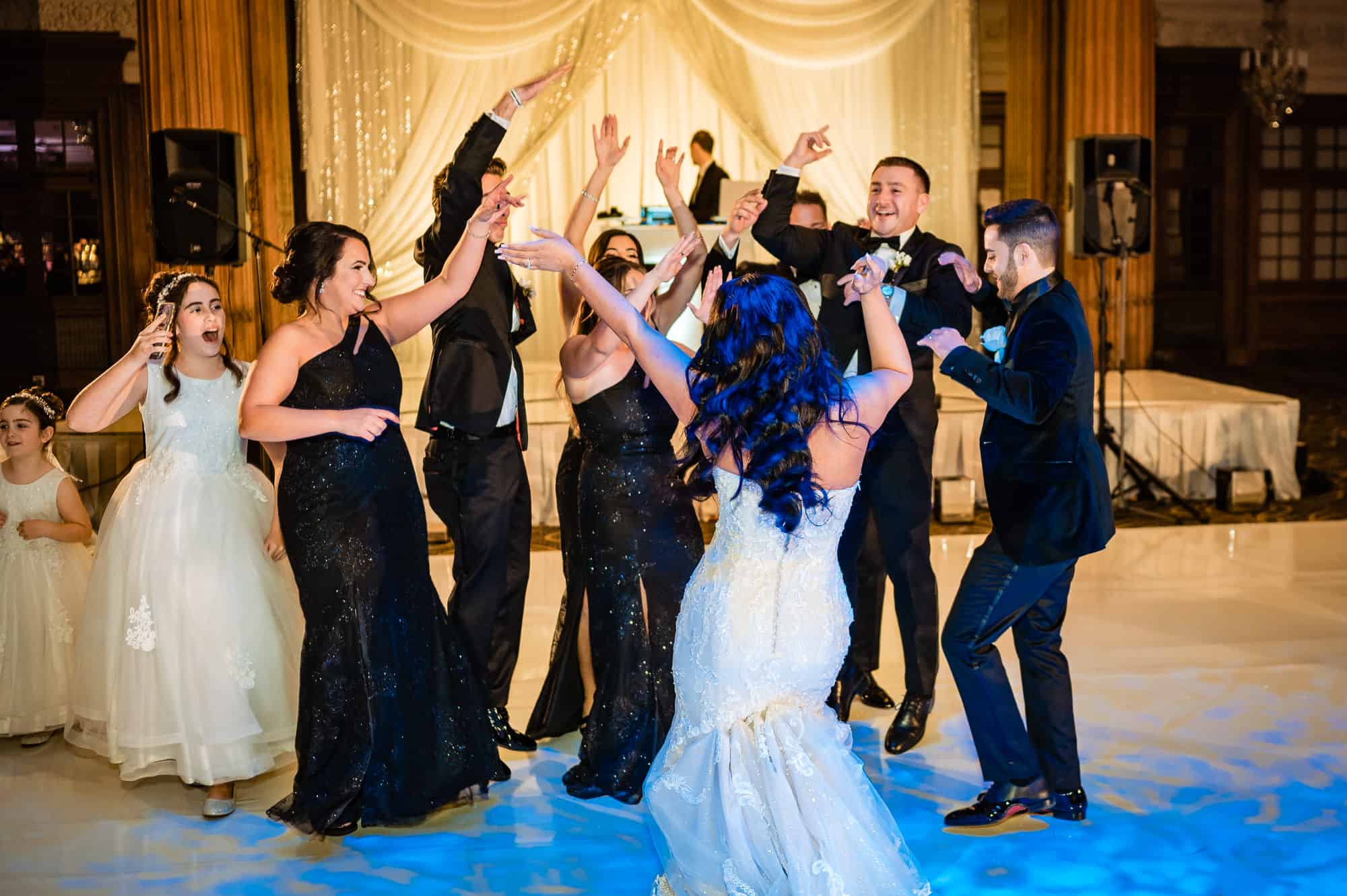 the wedding party having a blast on the dance floor with the newlyweds