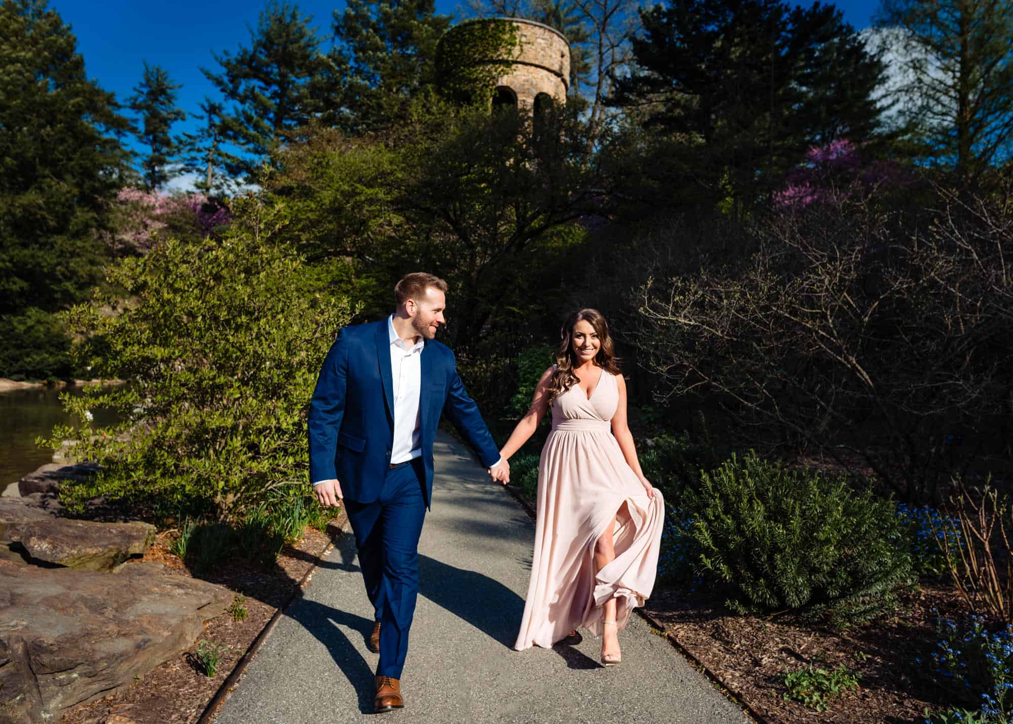 a summer engagement shoot taken outside the historic bell tower of longwood gardens