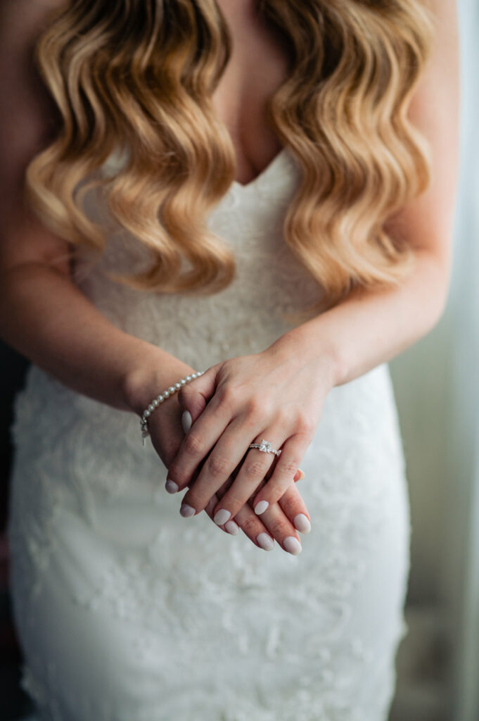 shot of the brides nails, ring, and pearl bracelet