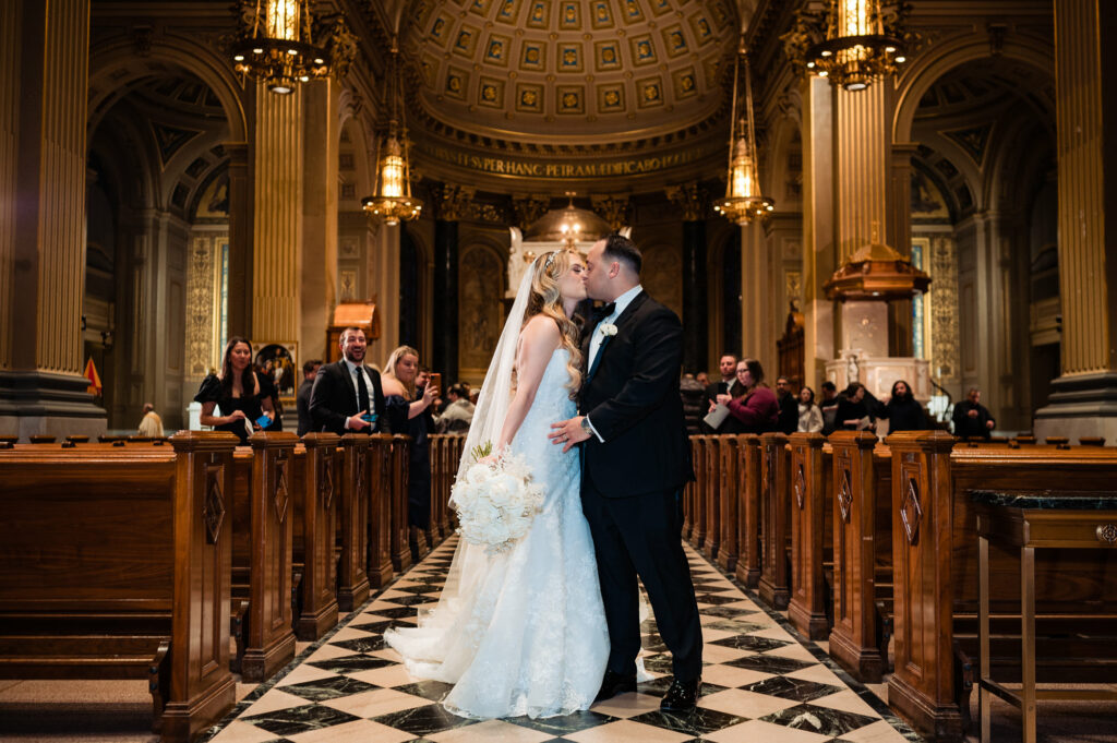 newlyweds kissing on the aisle