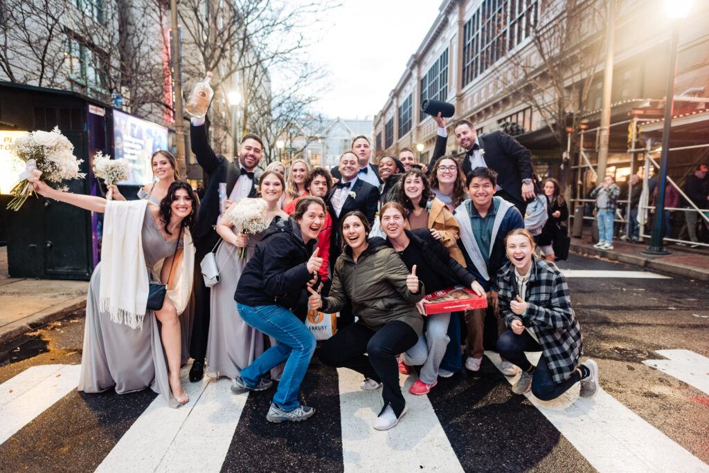 newlyweds posing in the middle of the street with the passerbys