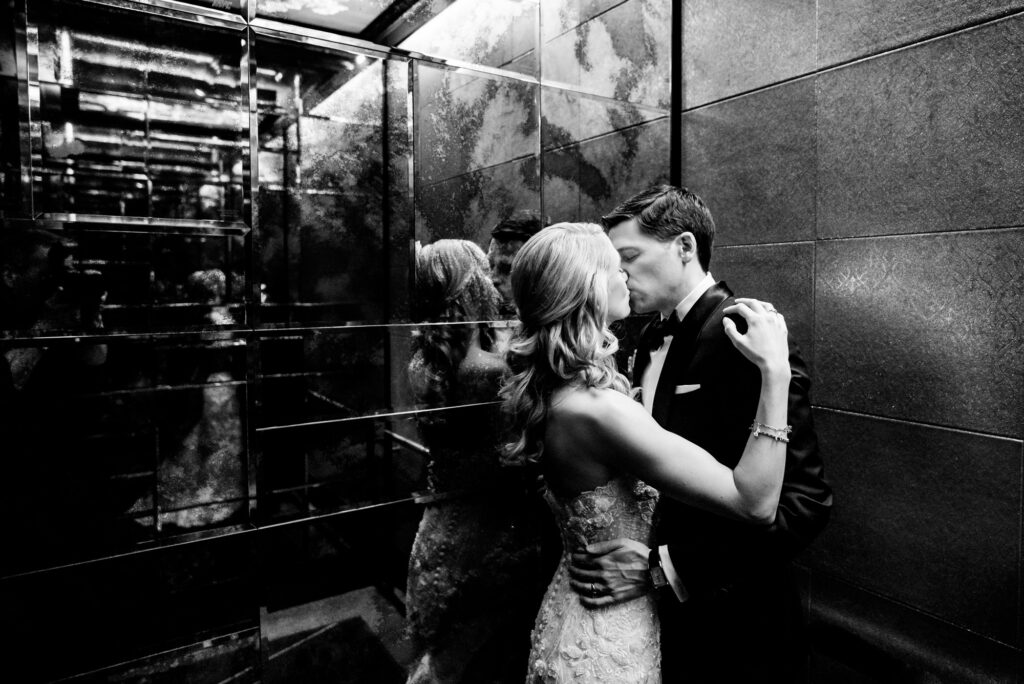 black and white shot of bride and groom kissing