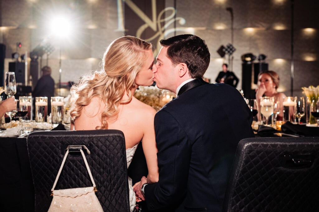bride and groom kissing at the wedding reception