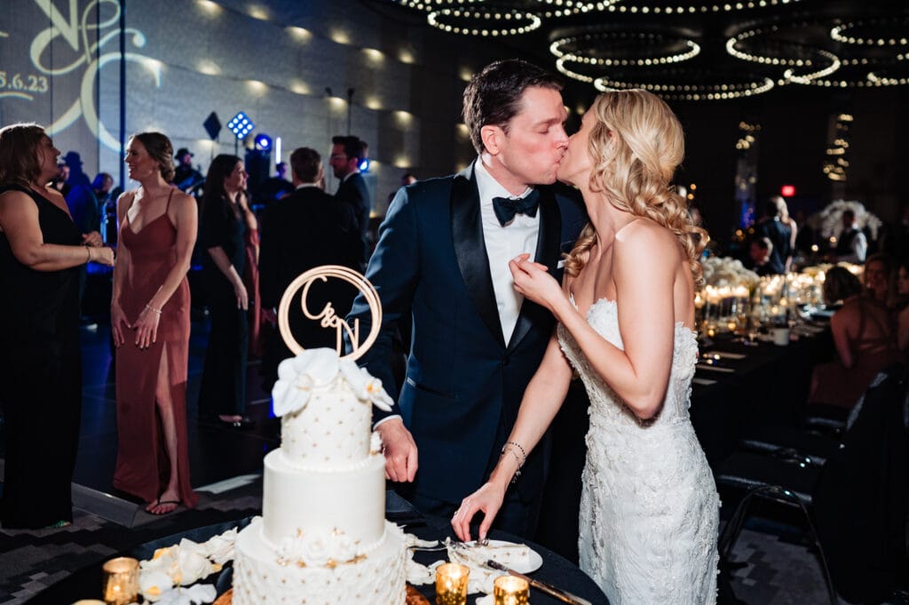 bride and groom kissing after cutting up their wedding cake